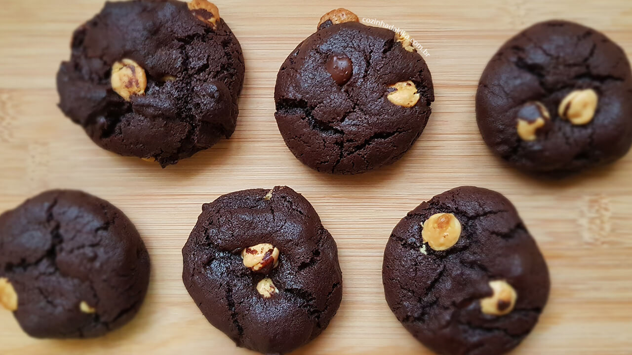 Cookies de chocolate com gotas de chocolate branco sobre uma tábua de madeira